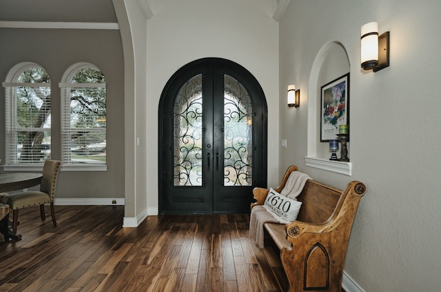 foyer entrance with crown molding, dark hardwood / wood-style floors, and french doors