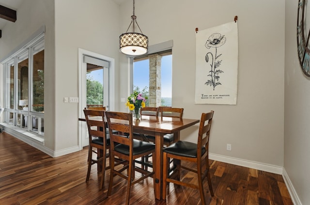 dining space with dark hardwood / wood-style floors and a towering ceiling