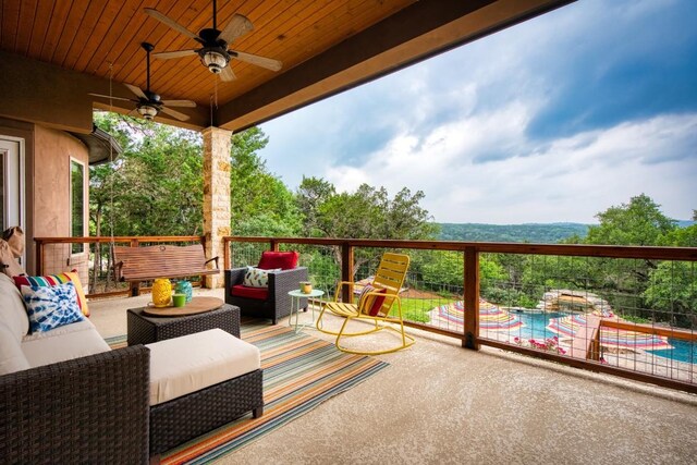 wooden deck with ceiling fan, an outdoor hangout area, and a fenced in pool