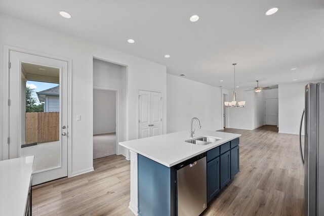 320 Creek Rd Unit 206, Dripping Springs, TX 78620 - kitchen with appliances with stainless steel finishes, a sink, light countertops, light wood-style flooring, and blue cabinets