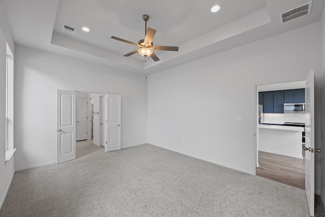 320 Creek Rd Unit 206, Dripping Springs, TX 78620 - unfurnished bedroom featuring a raised ceiling, light carpet, recessed lighting, a ceiling fan, and baseboards
