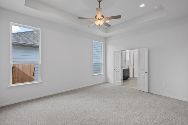 320 Creek Rd Unit 206, Dripping Springs, TX 78620 - unfurnished bedroom featuring a raised ceiling, multiple windows, light carpet, and baseboards