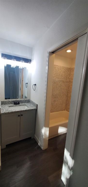 bathroom featuring baseboards, wood finished floors, and vanity