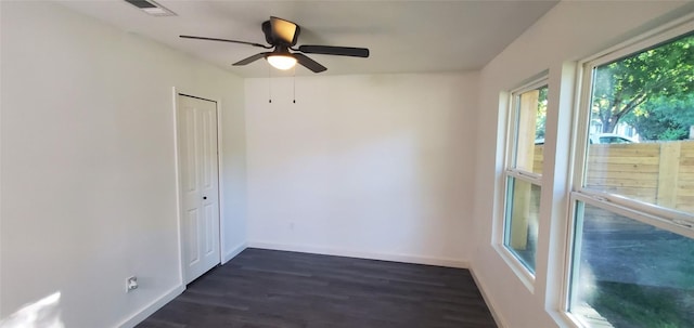 unfurnished room featuring ceiling fan, dark wood-type flooring, visible vents, and baseboards