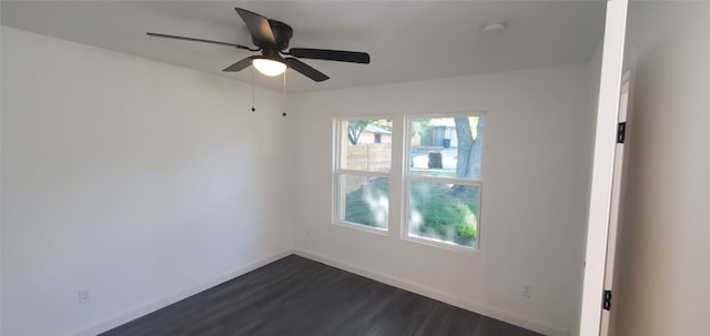 spare room featuring ceiling fan, baseboards, and dark wood-style flooring