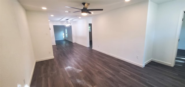 empty room with dark wood-style floors, ceiling fan, and baseboards