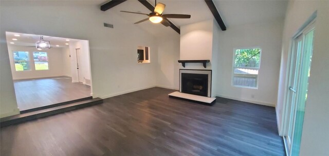 unfurnished living room featuring dark hardwood / wood-style floors, ceiling fan, a healthy amount of sunlight, and beam ceiling