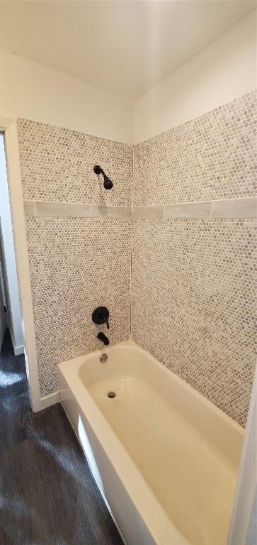 bathroom with tiled shower / bath combo and hardwood / wood-style floors