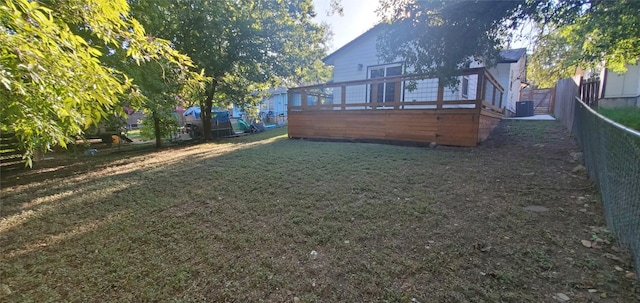 view of yard with a fenced backyard, a deck, and central AC