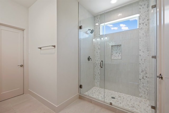 bathroom featuring a shower with door and tile patterned flooring