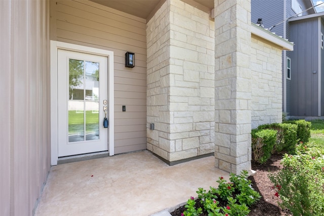 view of exterior entry featuring a patio