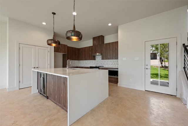 2646 Crazyhorse Pass, Austin, TX 78734 - kitchen featuring light countertops, wine cooler, a sink, concrete flooring, and backsplash