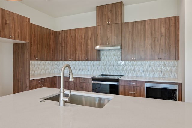 kitchen with sink, tasteful backsplash, stainless steel microwave, and electric range oven