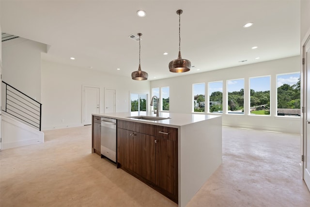 kitchen with sink, decorative light fixtures, dark brown cabinetry, stainless steel dishwasher, and an island with sink