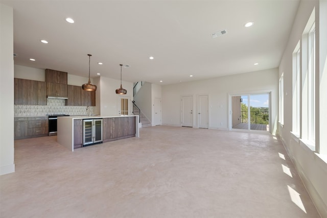 unfurnished living room with beverage cooler and sink