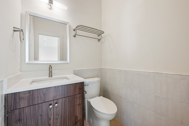 bathroom featuring tile walls, toilet, and vanity