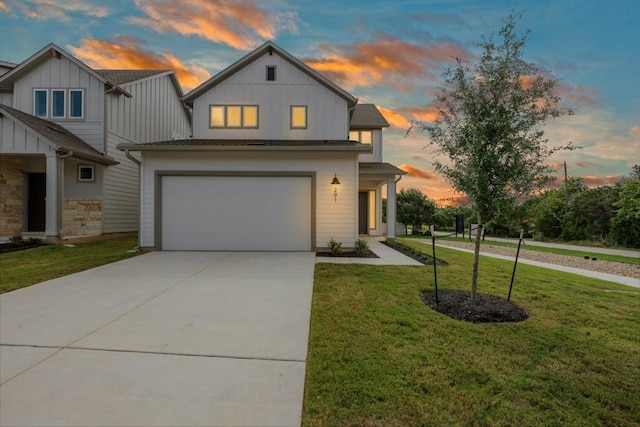 view of front of home with a garage and a lawn