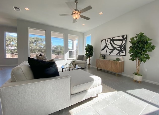 living room featuring tile patterned flooring, ceiling fan, and a healthy amount of sunlight