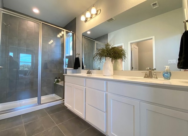 bathroom with tile patterned floors, a shower with door, and vanity