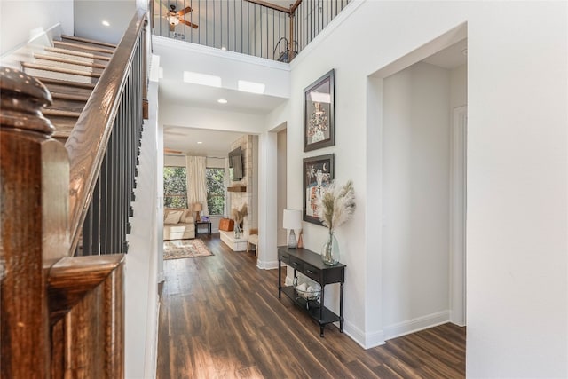 foyer featuring ceiling fan, dark hardwood / wood-style flooring, and a high ceiling