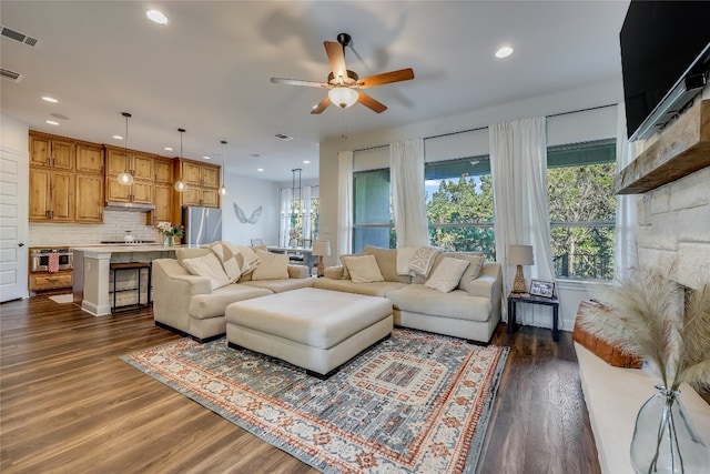 living room with ceiling fan and dark hardwood / wood-style flooring