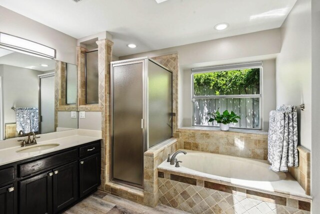 bathroom with vanity, plus walk in shower, and hardwood / wood-style floors