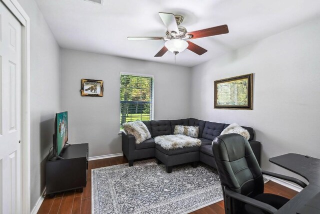 home office with ceiling fan and dark hardwood / wood-style flooring