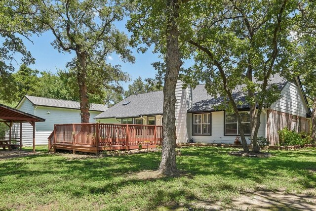 back of house featuring a wooden deck and a yard