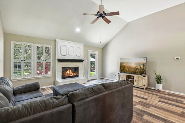 living room with a fireplace, wood-type flooring, high vaulted ceiling, and ceiling fan