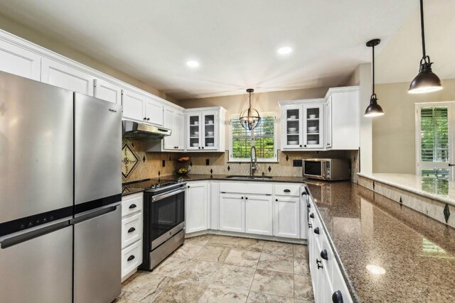 kitchen with sink, appliances with stainless steel finishes, pendant lighting, and tasteful backsplash