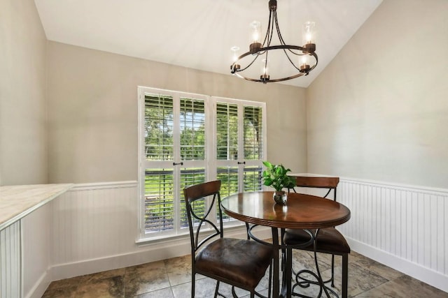 tiled dining room with vaulted ceiling and a notable chandelier