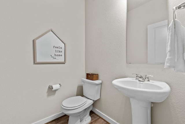 bathroom featuring hardwood / wood-style flooring, toilet, and sink