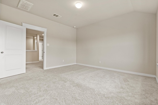 carpeted empty room with vaulted ceiling