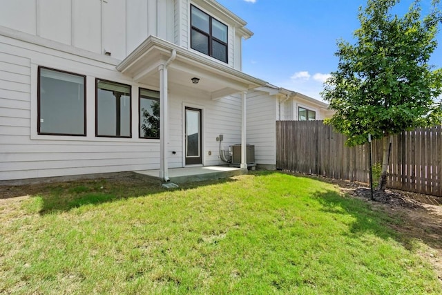 back of house featuring a yard, a patio, and central air condition unit