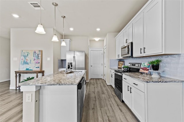 kitchen with stainless steel appliances, light hardwood / wood-style flooring, decorative light fixtures, a kitchen island with sink, and white cabinets