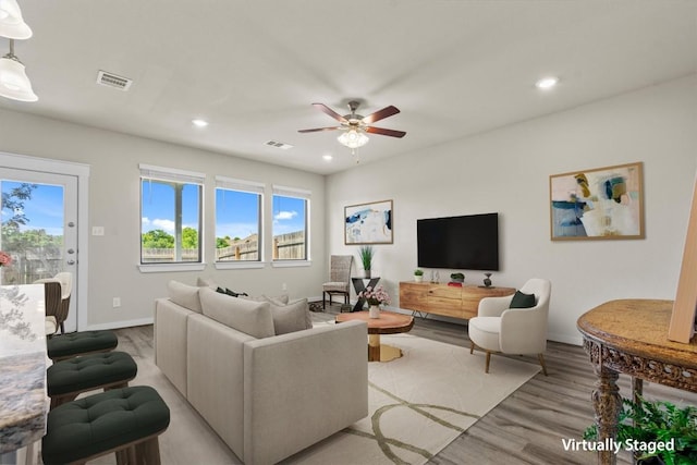 living room featuring ceiling fan and light wood-type flooring