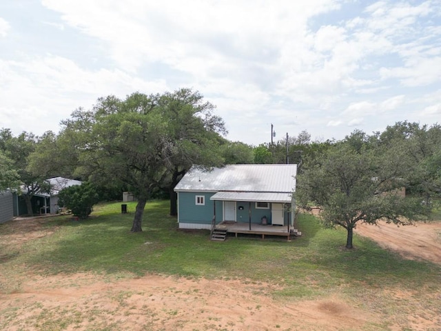 view of front of home with metal roof, a porch, and a front yard