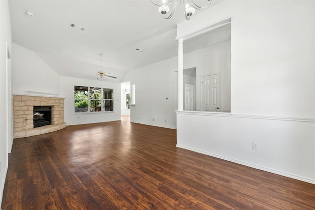 unfurnished living room featuring hardwood / wood-style flooring, vaulted ceiling, ceiling fan with notable chandelier, and a stone fireplace