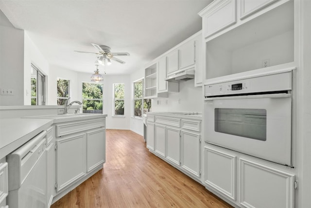 kitchen with light wood-type flooring, ceiling fan, white appliances, and white cabinetry