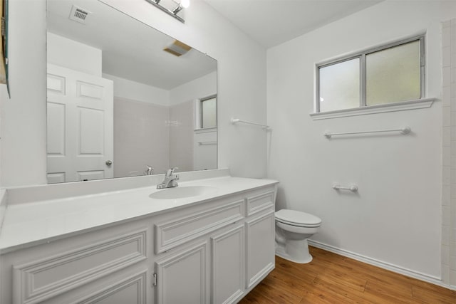 bathroom featuring wood-type flooring, toilet, and vanity