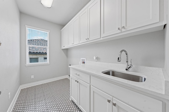 clothes washing area with cabinets, sink, light tile patterned floors, and washer hookup