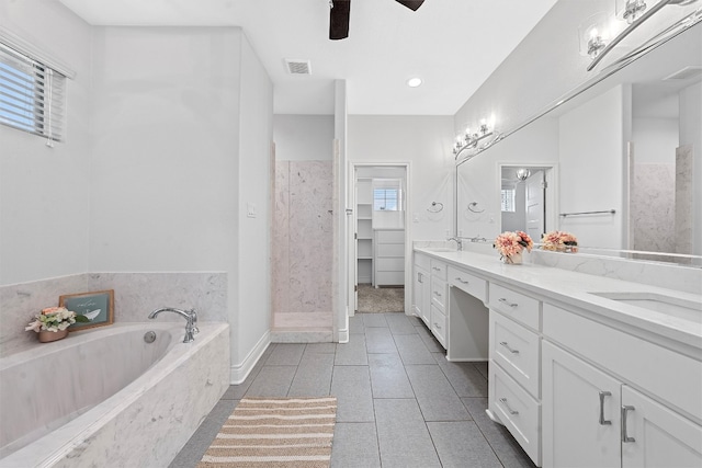 bathroom featuring tiled tub, dual vanity, tile patterned flooring, and ceiling fan