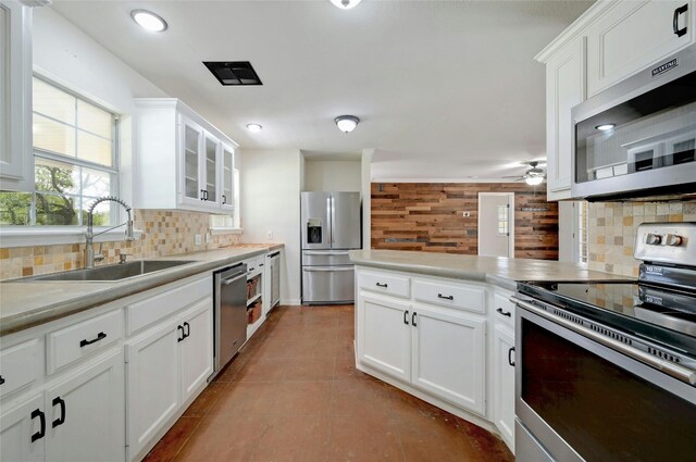 kitchen featuring stainless steel appliances, backsplash, light tile patterned flooring, white cabinetry, and ceiling fan