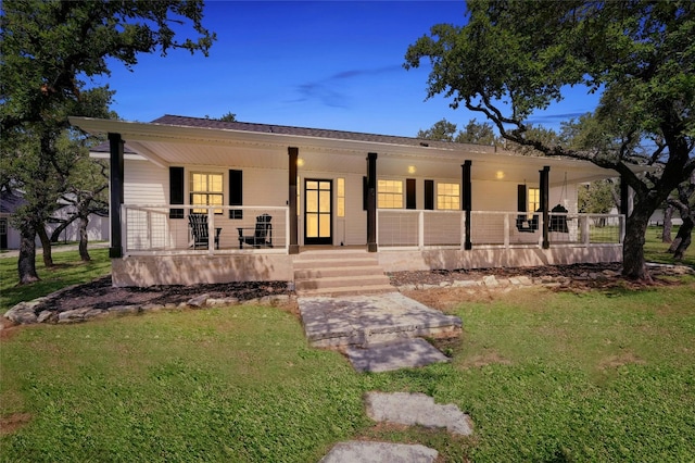 view of front of property featuring covered porch and a lawn