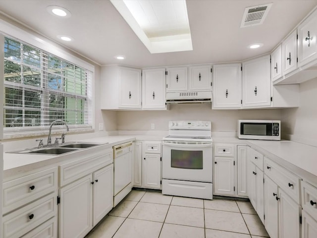 kitchen featuring white cabinets, light tile patterned flooring, white appliances, and sink