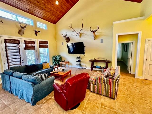 living room with light tile patterned floors, french doors, a towering ceiling, and wood ceiling