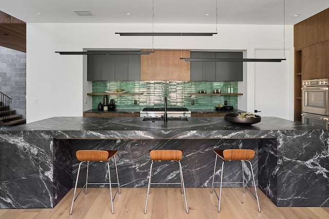 3003 Oakhaven Dr, Austin, TX 78704 - kitchen with modern cabinets, tasteful backsplash, and a kitchen breakfast bar