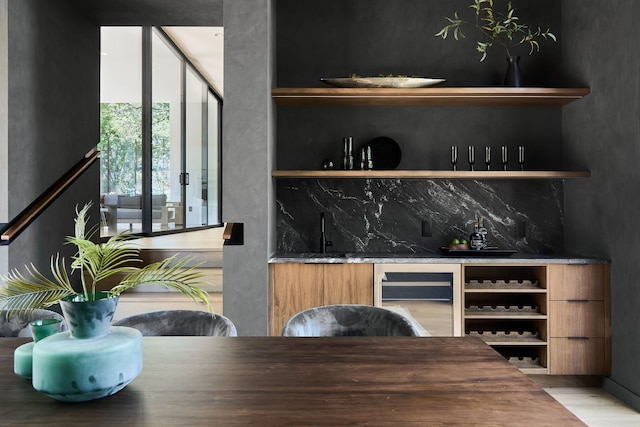 bar featuring decorative backsplash, hardwood / wood-style flooring, beverage cooler, and sink