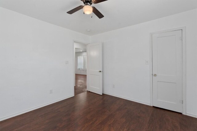 spare room with dark hardwood / wood-style floors and ceiling fan