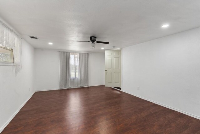 spare room with dark wood-type flooring and ceiling fan